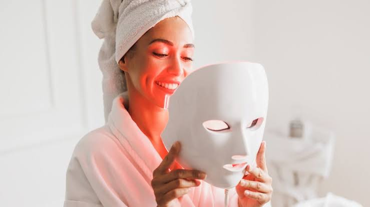Woman holding the LED face mask